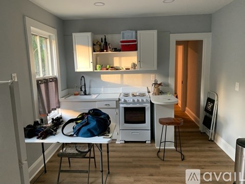 A kitchen with white appliances and wooden floors.