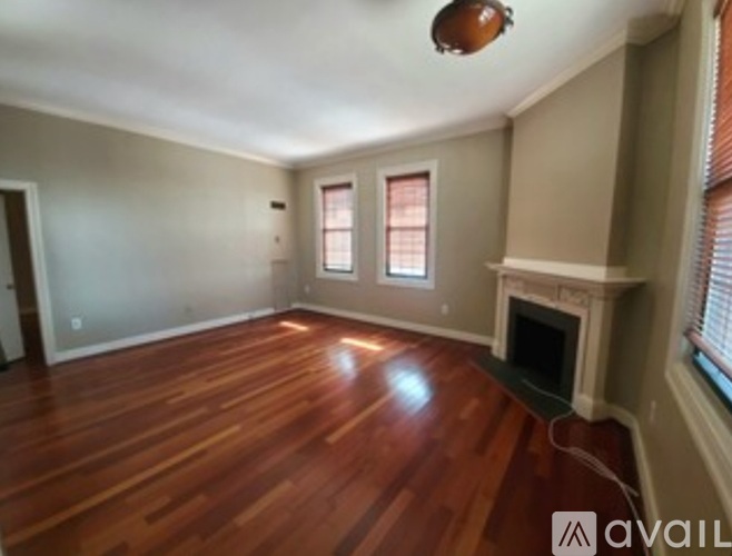 A room with wood flooring and a fireplace.