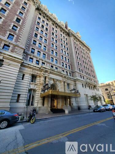A tall building with a balcony on the ground floor.