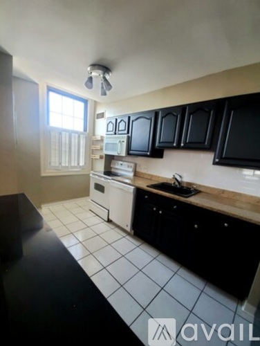 A kitchen with black cabinets and white tiles.