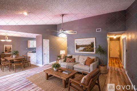 A living room with a couch, coffee table, and a painting on the wall.