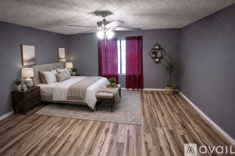A bedroom with a bed, nightstands, and a window with red curtains.