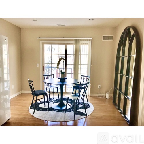 A dining room with a round table and chairs.
