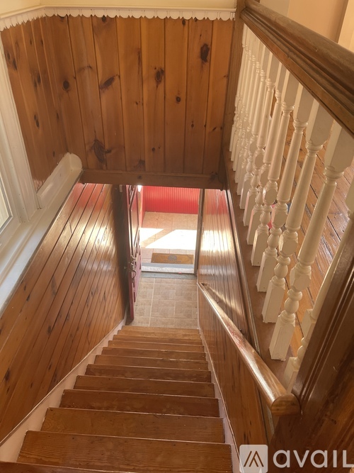 A wooden staircase with a white railing.