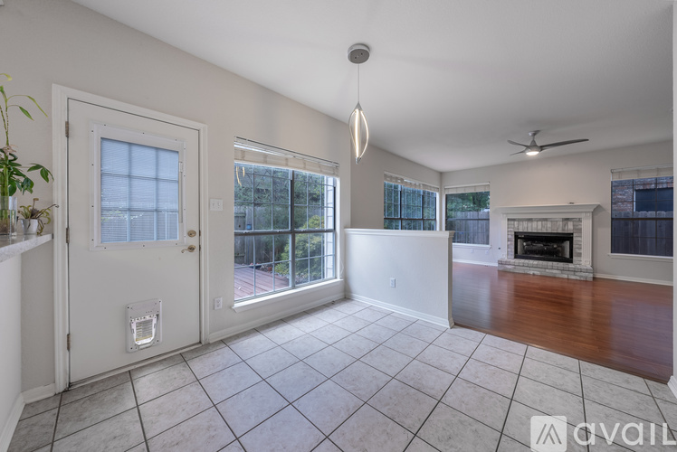 A spacious living room with a fireplace and a ceiling fan.