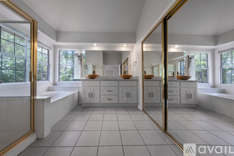 A spacious kitchen with white cabinets and a large mirror on the wall.