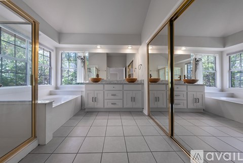A spacious kitchen with white cabinets and a large mirror on the wall.