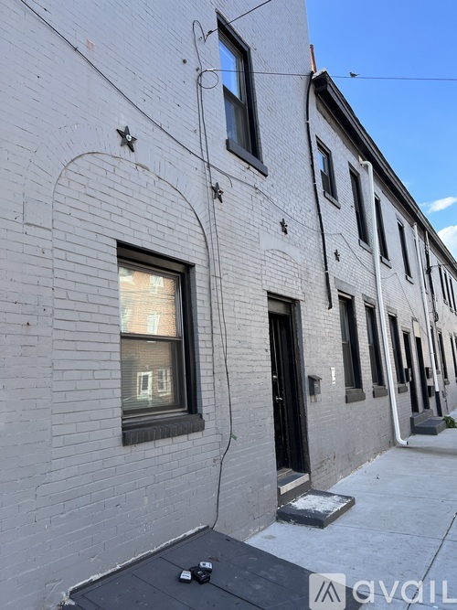 A white building with a black door and a window with a black frame.
