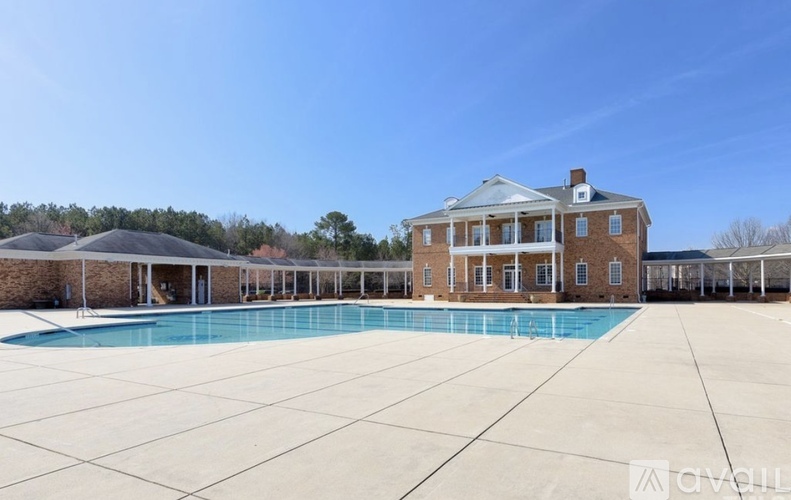 A large house with a pool in front.