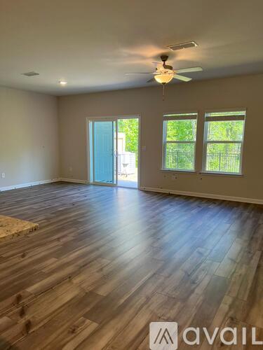 A room with wooden flooring and a ceiling fan.