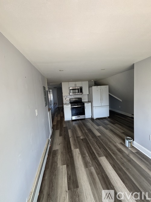 A kitchen with white cabinets and a wooden floor.