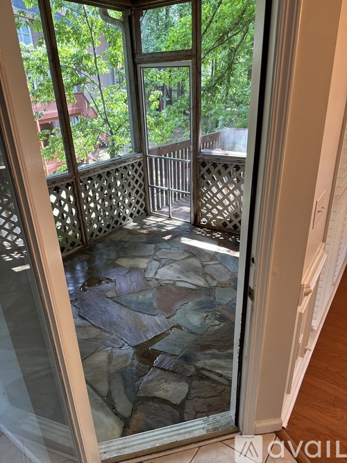 A glass door with a screen separates an interior space from an outdoor patio.