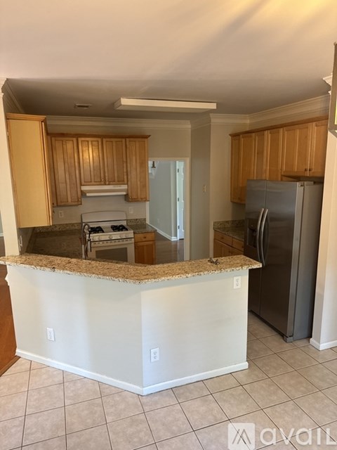 A kitchen with a granite countertop and wooden cabinets.