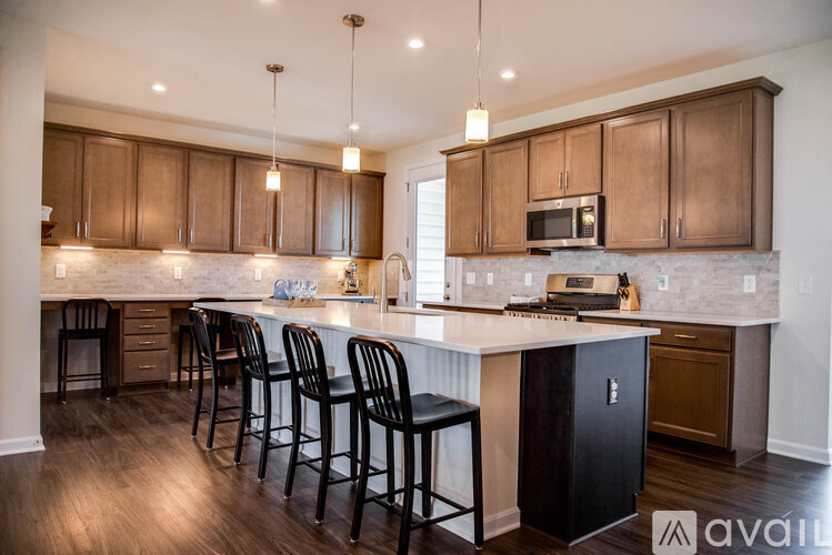 A kitchen with dark wood cabinets and a white countertop.