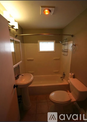 A bathroom with a toilet, sink, and bathtub.