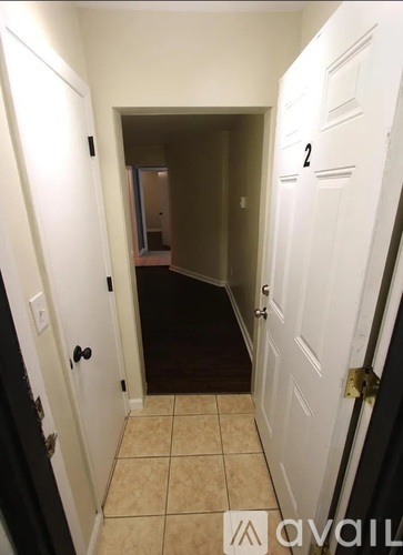 A hallway with a door on the right with a number 2 on it.
