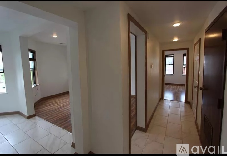 A hallway with a tiled floor and white walls.