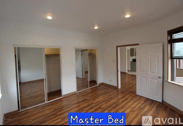 A room with wooden floors and white walls, labeled as "Master Bed".