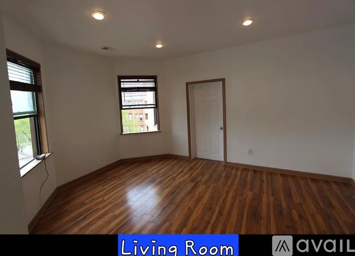A living room with wooden floors and a window.