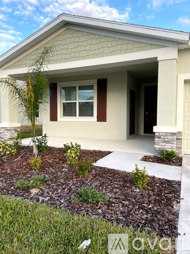 A house with a front yard and a tree.