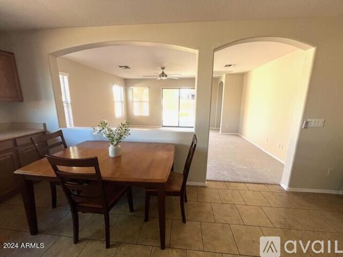 A dining room with a wooden table and chairs.