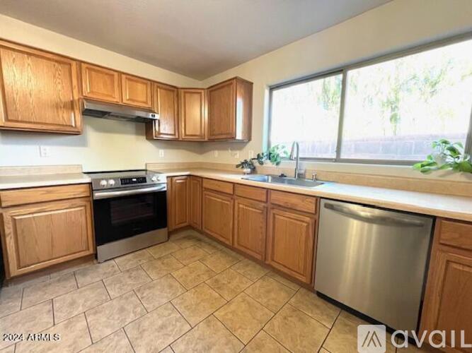 A kitchen with wooden cabinets and a stainless steel dishwasher.