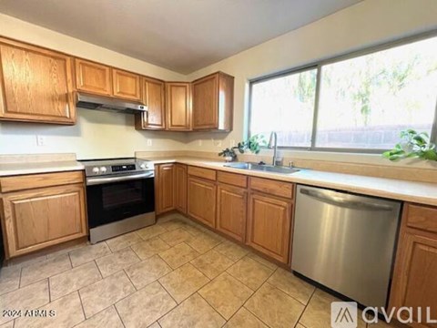 A kitchen with wooden cabinets and a stainless steel dishwasher.