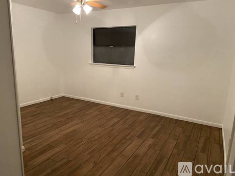 A room with a flat screen TV mounted on the wall and a ceiling fan.