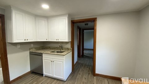 A kitchen with white cabinets and a granite countertop.