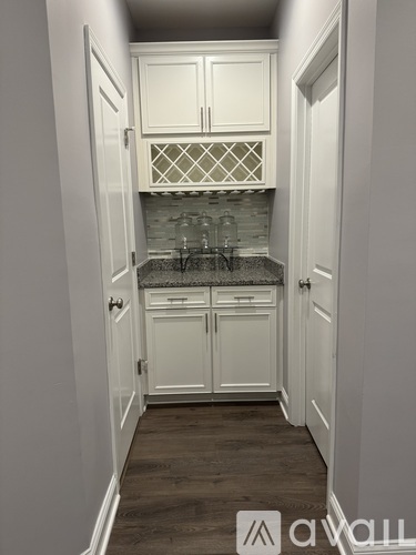 A small kitchen with white cabinets and a tile backsplash.