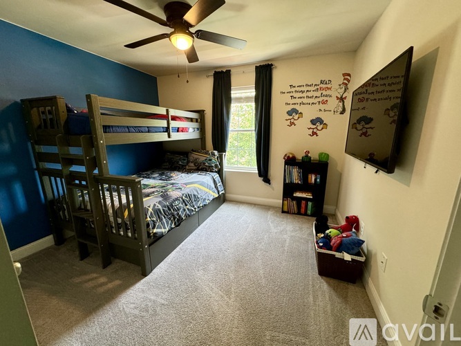A bedroom with a bunk bed and a ceiling fan.