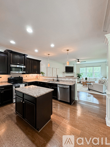 A kitchen with dark wood cabinets and a white island.