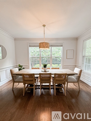 A dining room with a wooden table and chairs.