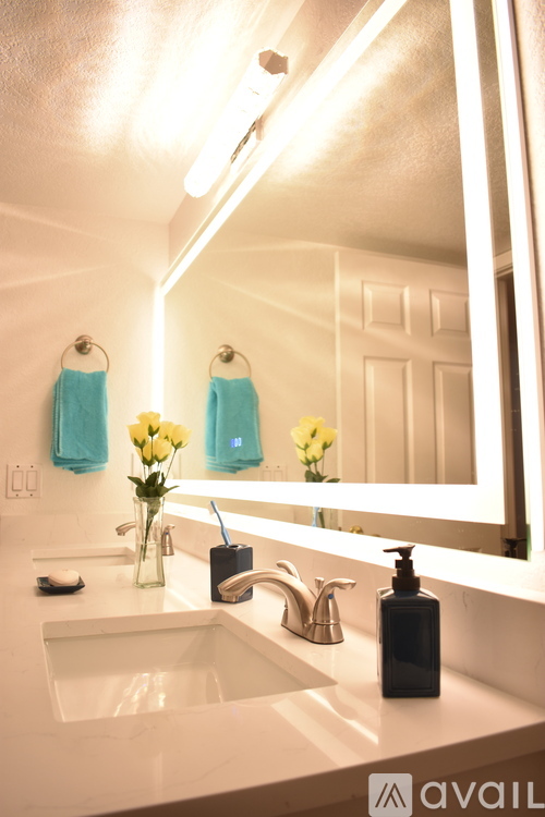 A bathroom with a sink, mirror, and towels.