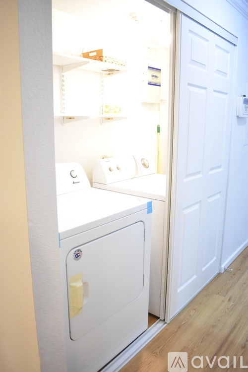 A white fridge with a yellow handle is in a room with a white door.
