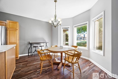 A dining room with a wooden table and chairs.