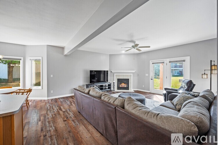 A living room with a brown couch and a fireplace.