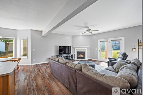 A living room with a brown couch and a fireplace.