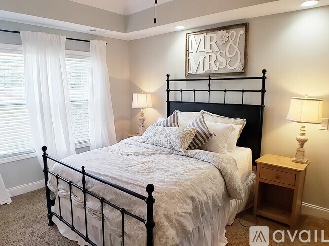 A bedroom with a large bed and a sign that says "Mr & Mrs" on the wall.