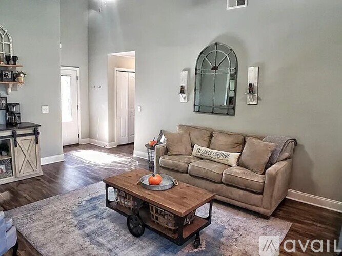 A living room with a couch, coffee table, and a rug.