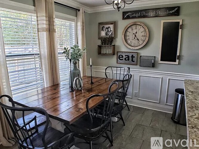A dining room with a wooden table and chairs.