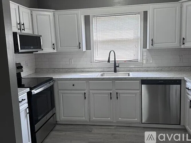 A kitchen with white cabinets and a black oven.