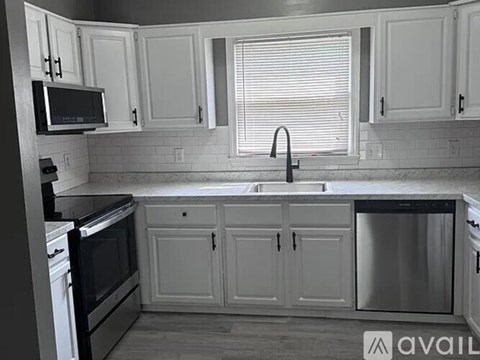 A kitchen with white cabinets and a black oven.