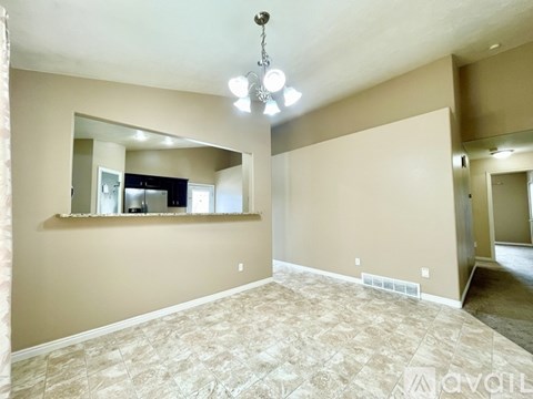 A spacious room with a large mirror and a chandelier.