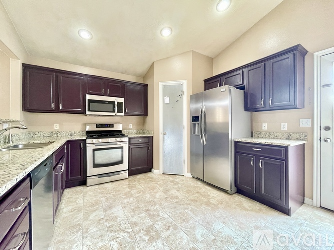 A kitchen with purple cabinets and a stainless steel refrigerator.