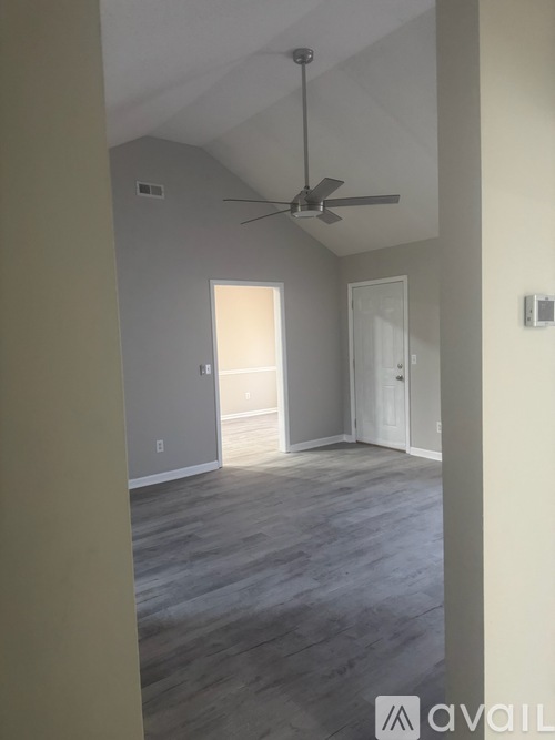 A room with a ceiling fan and light switch.