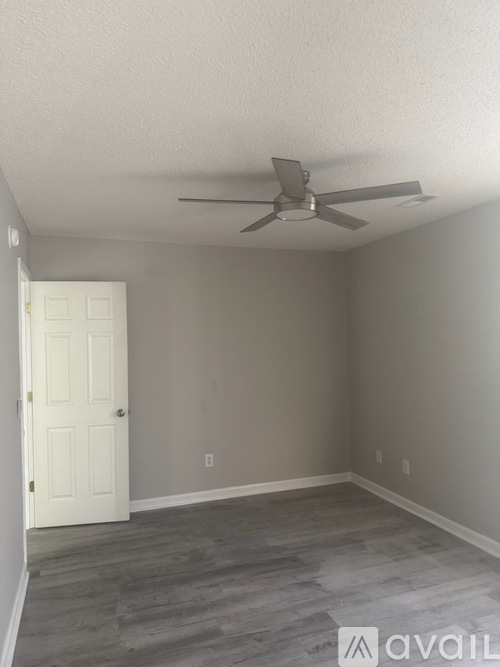 A room with a ceiling fan and a door.