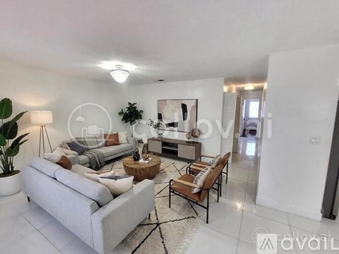 A modern living room with a grey sofa, wooden coffee table, and a large painting on the wall.