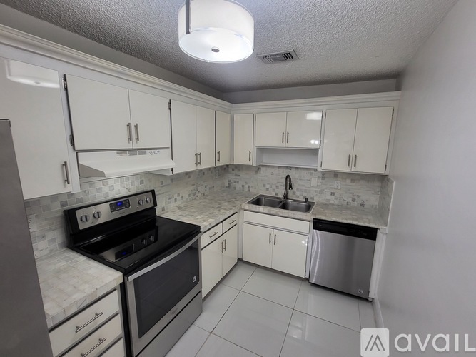 A kitchen with white cabinets and a black stove top oven.