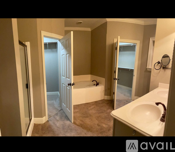 A bathroom with a tub, sink, and mirror.